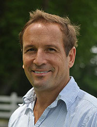 Headshot of a blond white man in a white button-down shirt.