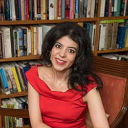 Headshot of a light-skinned brown woman with mid-length black hair wearing red top