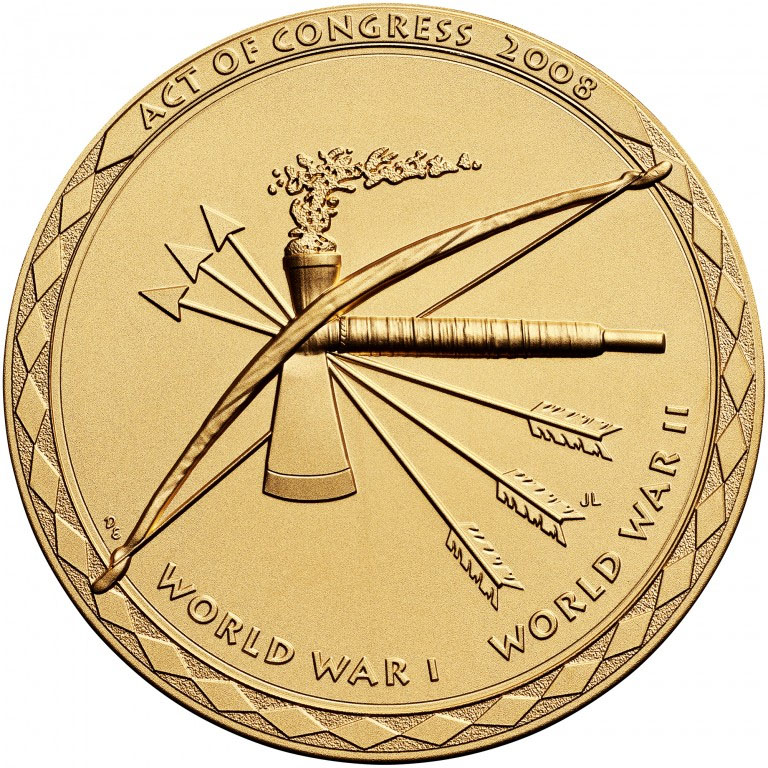 Modern photograph of a bronze-gold-colored medal engraved with a bow, three fletched arrows and a pipe hatchet.