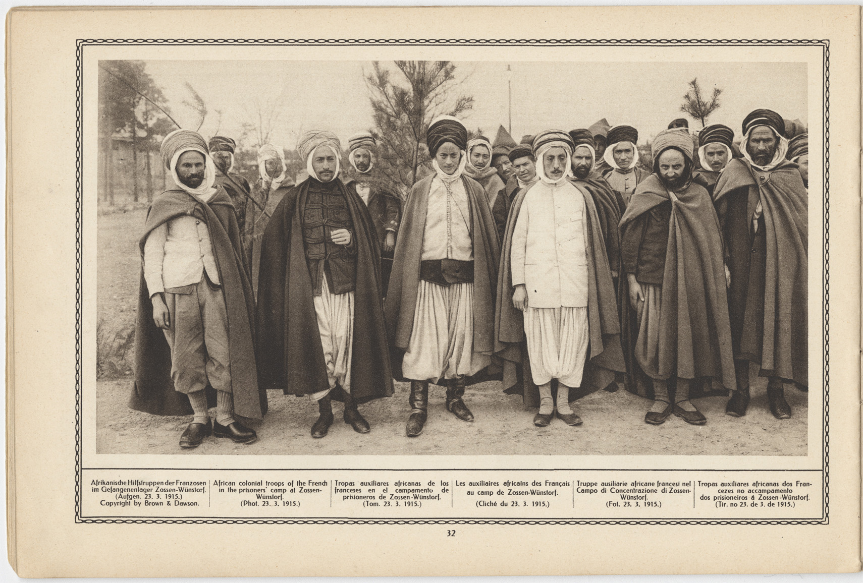 Scan of a vintage magazine page featuring a black and white photograph of a large group of Muslim men dressed in loose robes and head coverings posed for a standing group portrait. The captions underneath are written in five languages.