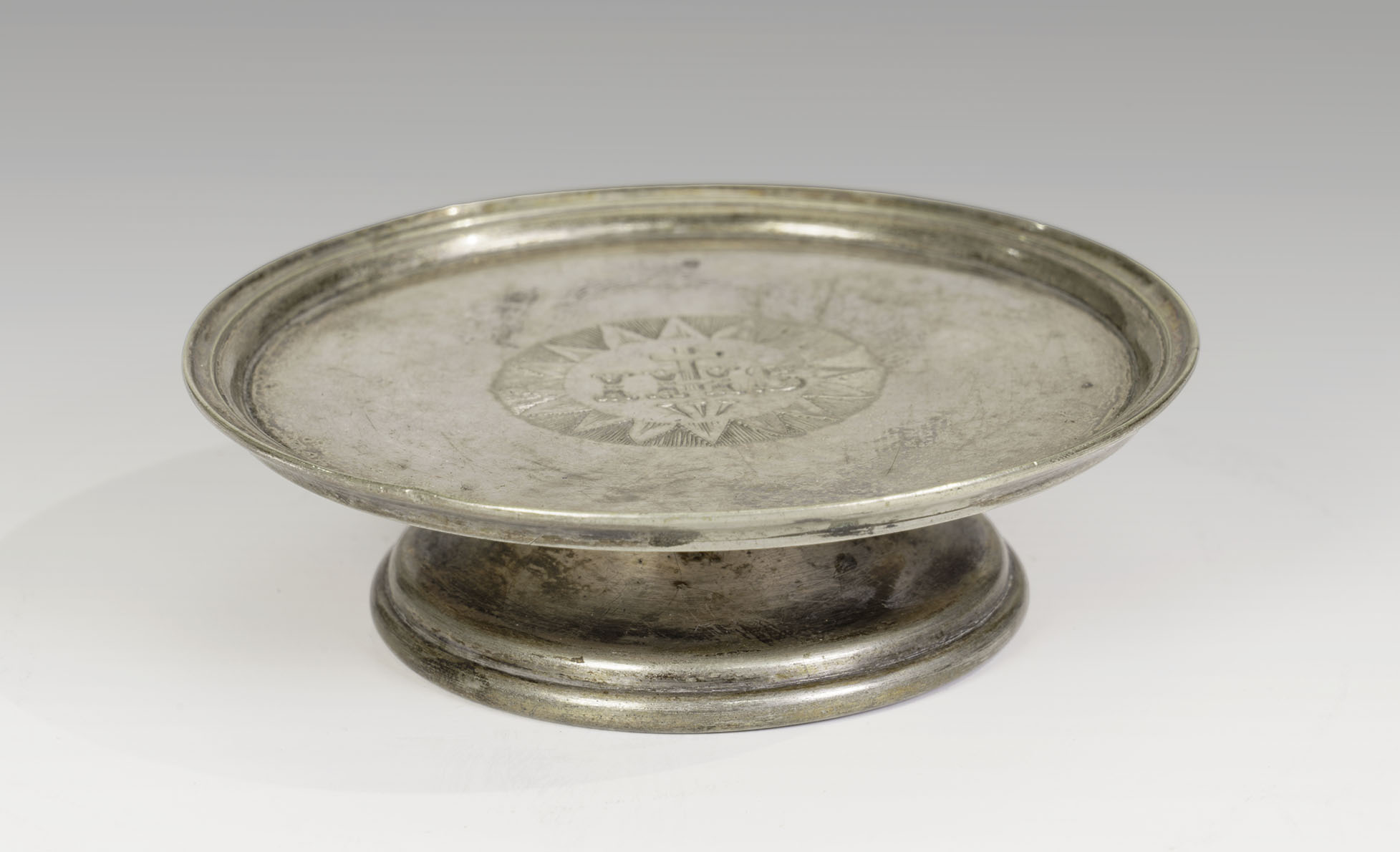 Modern photograph of a silver plate on its own low silver stand